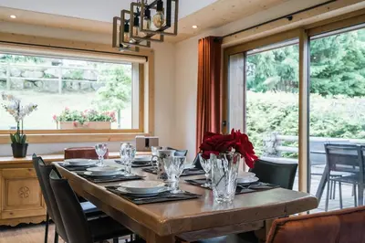 a dining room with a large wooden table with chairs at Appartement JASIONE-MEGEVE in Megève