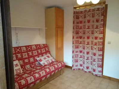 a room with a bed and a red and white blanket at Studio 4 pers Centre Station - Animaux OK - FR-1-836-65 in Arâches-la-Frasse