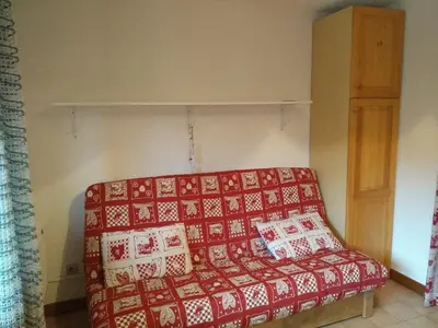 a red couch with pillows on it in a room at Studio 4 pers Centre Station - Animaux OK - FR-1-836-65 in Arâches-la-Frasse