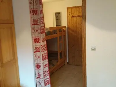 a room with a room with a bunk bed and a door at Studio 4 pers Centre Station - Animaux OK - FR-1-836-65 in Arâches-la-Frasse