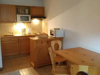 a kitchen with a wooden table and a table and a microwave at Charmant Appartement au Centre, Animaux Admis, 4 pers. - FR-1-836-64 in Arâches-la-Frasse