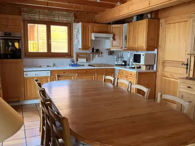 a large kitchen with a wooden table and chairs at Chalet lumineux pour 11 pers à 2 pas de Flaine avec parking - FR-1-572-351 in Arâches-la-Frasse