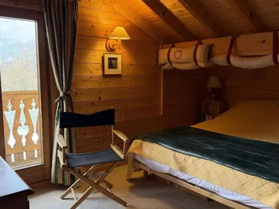 a bedroom with a bed and a chair in a cabin at Chalet lumineux pour 11 pers à 2 pas de Flaine avec parking - FR-1-572-351 in Arâches-la-Frasse