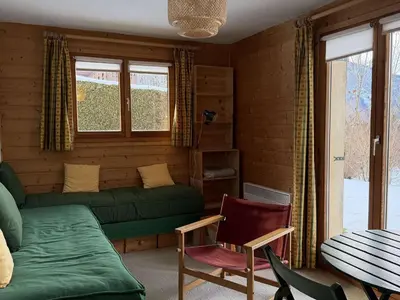 a living room with a green couch and a chair at Chalet lumineux pour 11 pers à 2 pas de Flaine avec parking - FR-1-572-351 in Arâches-la-Frasse