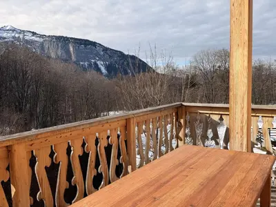 a wooden table on a balcony with a view of a mountain at Chalet lumineux pour 11 pers à 2 pas de Flaine avec parking - FR-1-572-351 in Arâches-la-Frasse