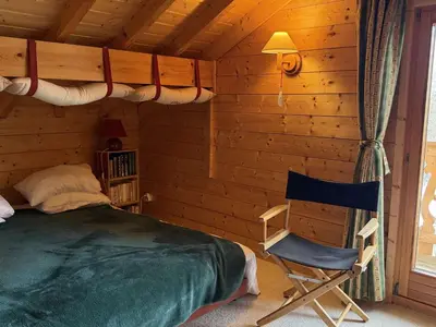 a bedroom with a bed and a chair in a cabin at Chalet lumineux pour 11 pers à 2 pas de Flaine avec parking - FR-1-572-351 in Arâches-la-Frasse