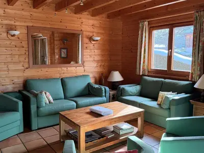 a living room with blue couches and a table at Chalet lumineux pour 11 pers à 2 pas de Flaine avec parking - FR-1-572-351 in Arâches-la-Frasse