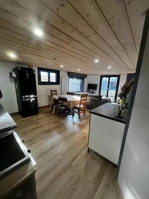 a kitchen and a living room with a table and chairs at Appartement chaleureux et proche de station de ski in Sallanches