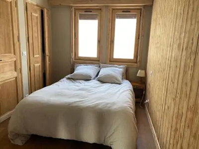 a bedroom with a large bed with two windows at Soul Megève Panoramic View, Fireplace, Parking in Megève
