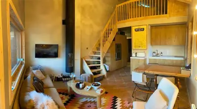 a living room with a couch and a kitchen at Soul Megève Panoramic View, Fireplace, Parking in Megève