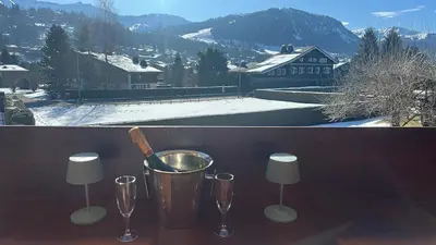 a table with two wine glasses and a bucket at Soul Megève Panoramic View, Fireplace, Parking in Megève