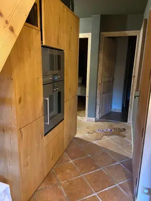 a kitchen with wooden cabinets and a tiled floor at Soul Megève Panoramic View, Fireplace, Parking in Megève