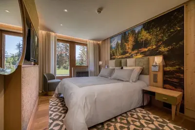 a bedroom with a bed with a large painting on the wall at Chalet Le 34 Megève - Chalet dexception in Le Planellet