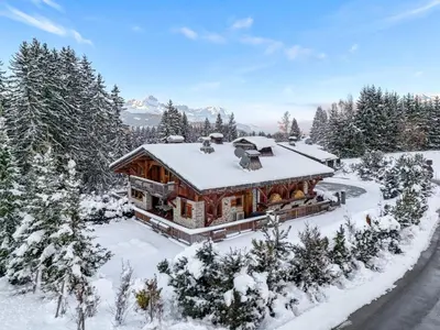 a log home in the snow with snow covered trees at Chalet Le 34 Megève - Chalet dexception in Le Planellet