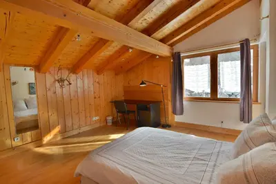 a bedroom with a bed and a desk in a room at Chalet vallée de Chamonix, vue glaciers MontBlanc by ImmoConciergerie in Les Houches