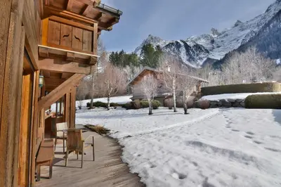 a snow covered porch of a house with a snow covered yard at Chalet vallée de Chamonix, vue glaciers MontBlanc by ImmoConciergerie in Les Houches