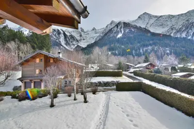a house in the snow with mountains in the background at Chalet vallée de Chamonix, vue glaciers MontBlanc by ImmoConciergerie in Les Houches