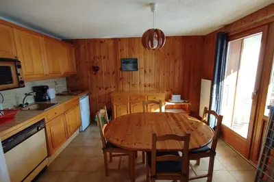a kitchen with a wooden table and a table and chairs at Apt or chalet near the village Combloux in Combloux
