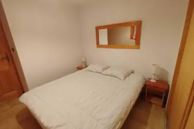 a small bedroom with a white bed and a mirror at Apt or chalet near the village Combloux in Combloux