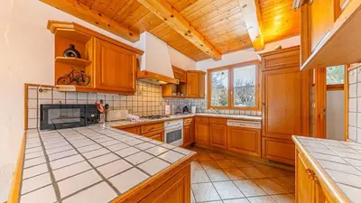 a kitchen with wooden cabinets and a counter top at White Chalet in Combloux