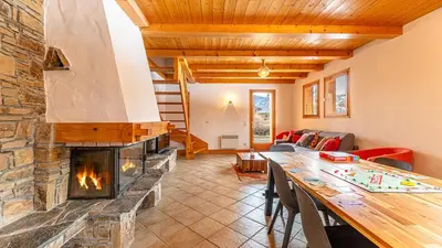 a living room with a fireplace and a table at White Chalet in Combloux