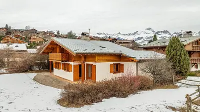 a house in the snow with mountains in the background at White Chalet in Combloux