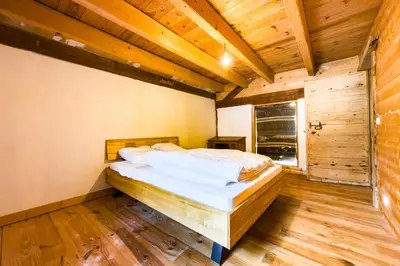 a bedroom with a bed in a room with wooden floors at Apartment near the slopes in Servoz in Servoz
