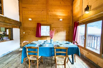 a dining room with a blue table and chairs at Apartment near the slopes in Servoz in Servoz