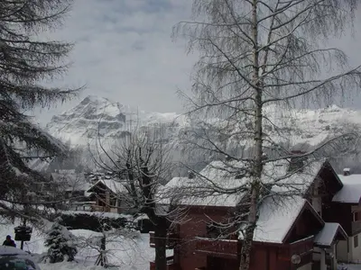 a snow covered mountain in the distance with a house at 2 Pièces Cabine près des Pistes avec Parking Inclus - FR-1-572-352 in Arâches-la-Frasse
