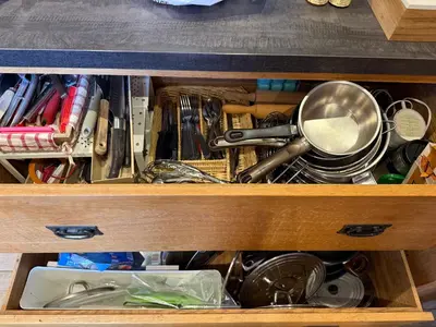 a wooden drawer filled with utensils and other items at Chalet du Gouter in Les Houches