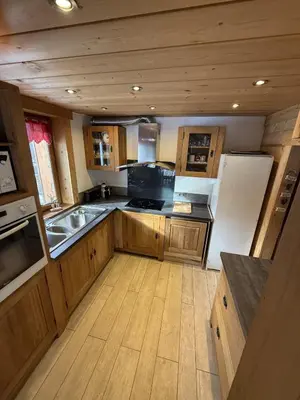 a large kitchen with wooden cabinets and a sink at Chalet du Gouter in Les Houches