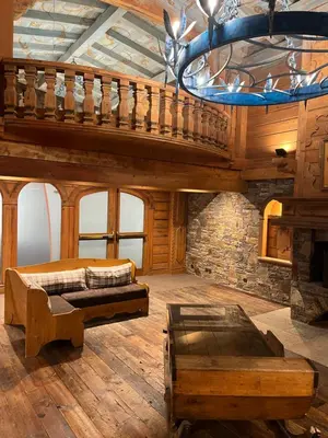 a large room with a staircase and a chandelier at Bel appartement avec vue exceptionnelle in Chamonix-Mont-Blanc
