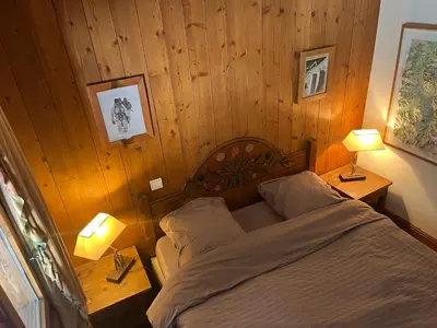 a bedroom with a bed and two lamps on tables at Bel appartement avec vue exceptionnelle in Chamonix-Mont-Blanc