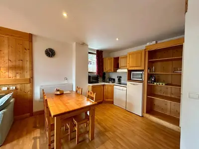 a kitchen with a wooden table and white appliances at La grande cordée in Combloux
