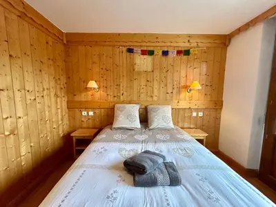 a bed in a room with wooden walls at La grande cordée in Combloux