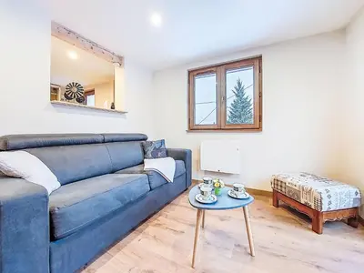 a living room with a blue couch and a table at Apartment Vent d'Est by Interhome in Mémontel