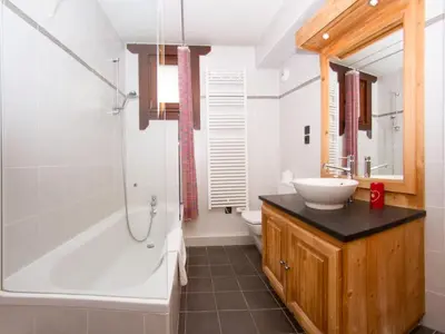 a bathroom with a tub and a sink and a toilet at Apartment Le Paradis Ski Wohnung by Interhome in Chamonix-Mont-Blanc