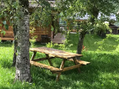 a wooden picnic table sitting next to a tree at Chalet Du Goûter Room Bionnassay, Les Houches in Les Houches