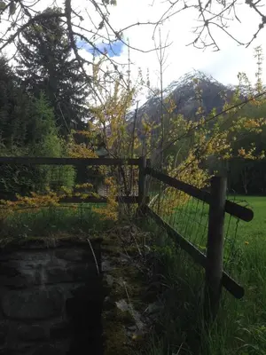 a fence in a field with mountains in the background at Chalet Du Goûter Room Bionnassay, Les Houches in Les Houches
