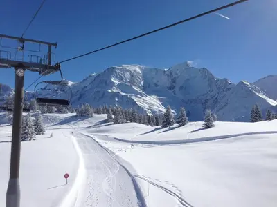 a ski slope with a ski lift and snow covered mountains at Chalet Du Goûter Room Bionnassay, Les Houches in Les Houches