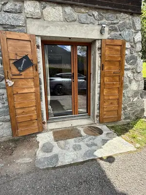a stone building with two doors and a window at Chalet Du Goûter Room Bionnassay, Les Houches in Les Houches
