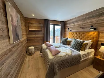 a bedroom with a bed with a wooden wall at Chalet Khione in Chamonix-Mont-Blanc