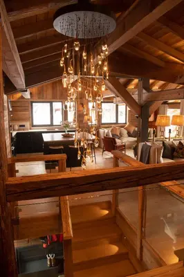 a chandelier hangs from the ceiling of a living room at Chalet Khione in Chamonix-Mont-Blanc