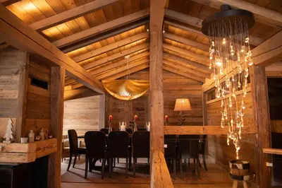 a dining room with a table and a chandelier at Chalet Khione in Chamonix-Mont-Blanc
