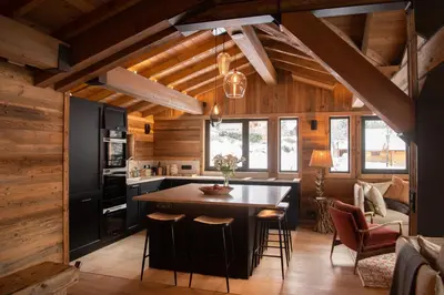 a kitchen with a large island in a room with wooden walls at Chalet Khione in Chamonix-Mont-Blanc