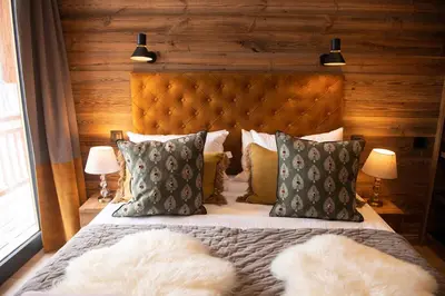 a bedroom with a large bed with two lamps at Chalet Khione in Chamonix-Mont-Blanc
