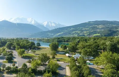 a park with a lake and mountains in the background at Camping Les Iles in Passy