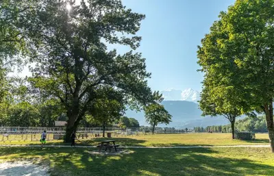a picnic table in a park with mountains in the background at Camping Les Iles in Passy