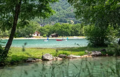 a lake with boats in the water and trees at Camping Les Iles in Passy