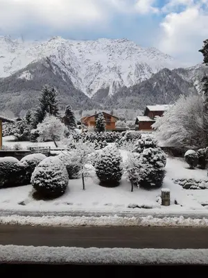 a garden covered in snow with mountains in the background at L'Alp'Inn - 4 pax, Chamonix Valley - Cozy Flat, Ski & Supermarket in Les Houches